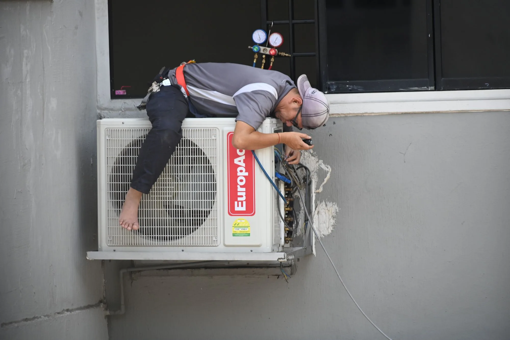 Engineer installing and servicing an air conditioning unit